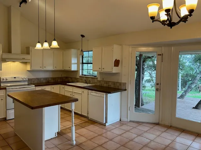a kitchen with a counter space a sink appliances and cabinets