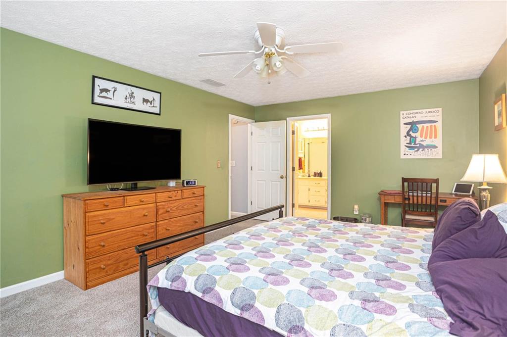 3838 Hunting Ridge Drive Southwest Lilburn, GA 30047 - Photo 29 of 56 a bedroom with a bed and a flat screen tv