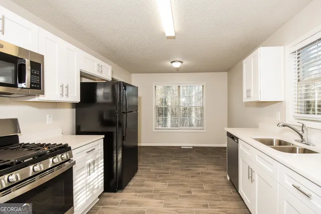 a kitchen with a stove a sink and a microwave