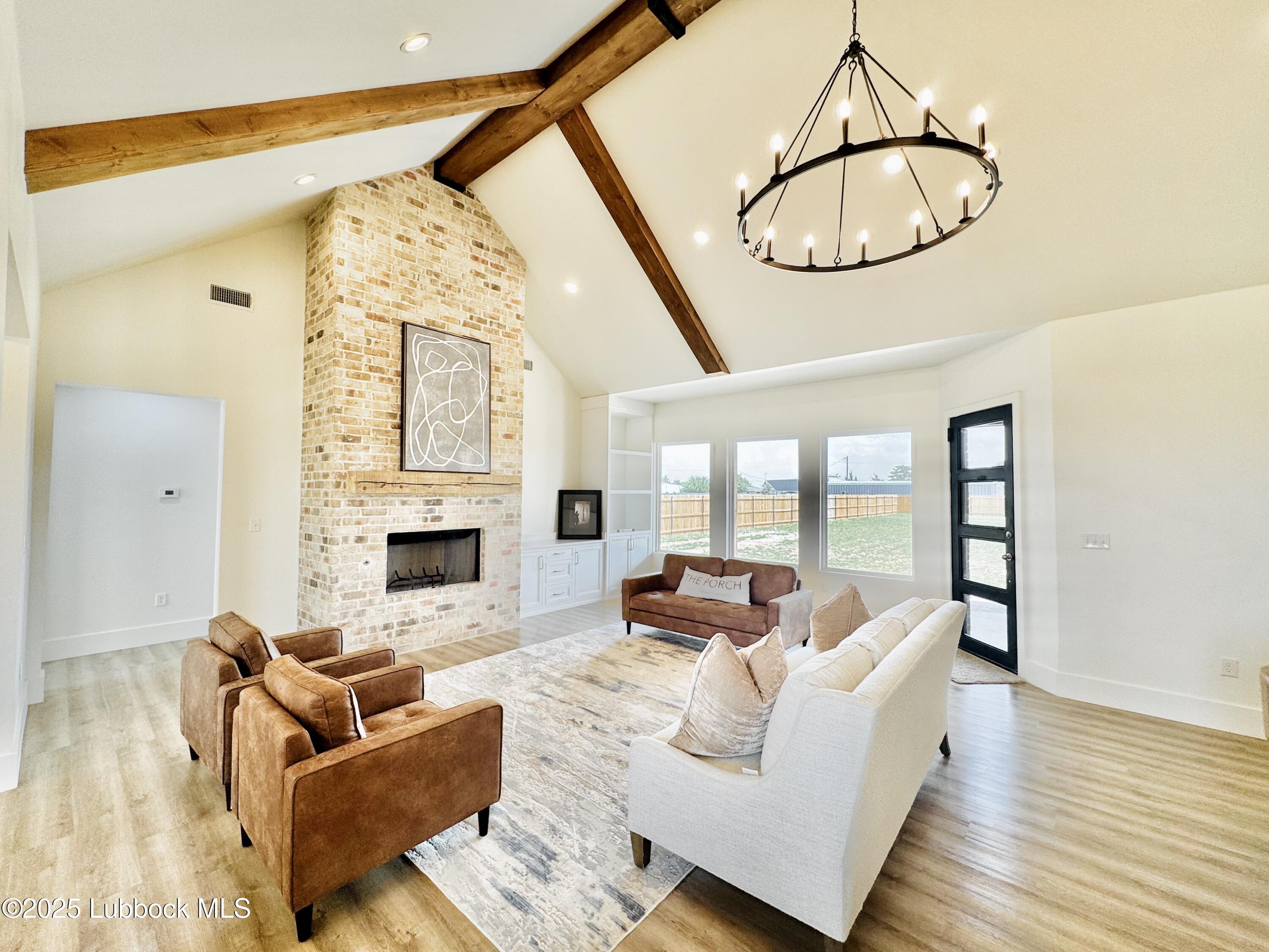 7211 West 12th Street Plainview, TX 79072 - Photo 14 of 48 a living room with furniture chandelier and a fireplace
