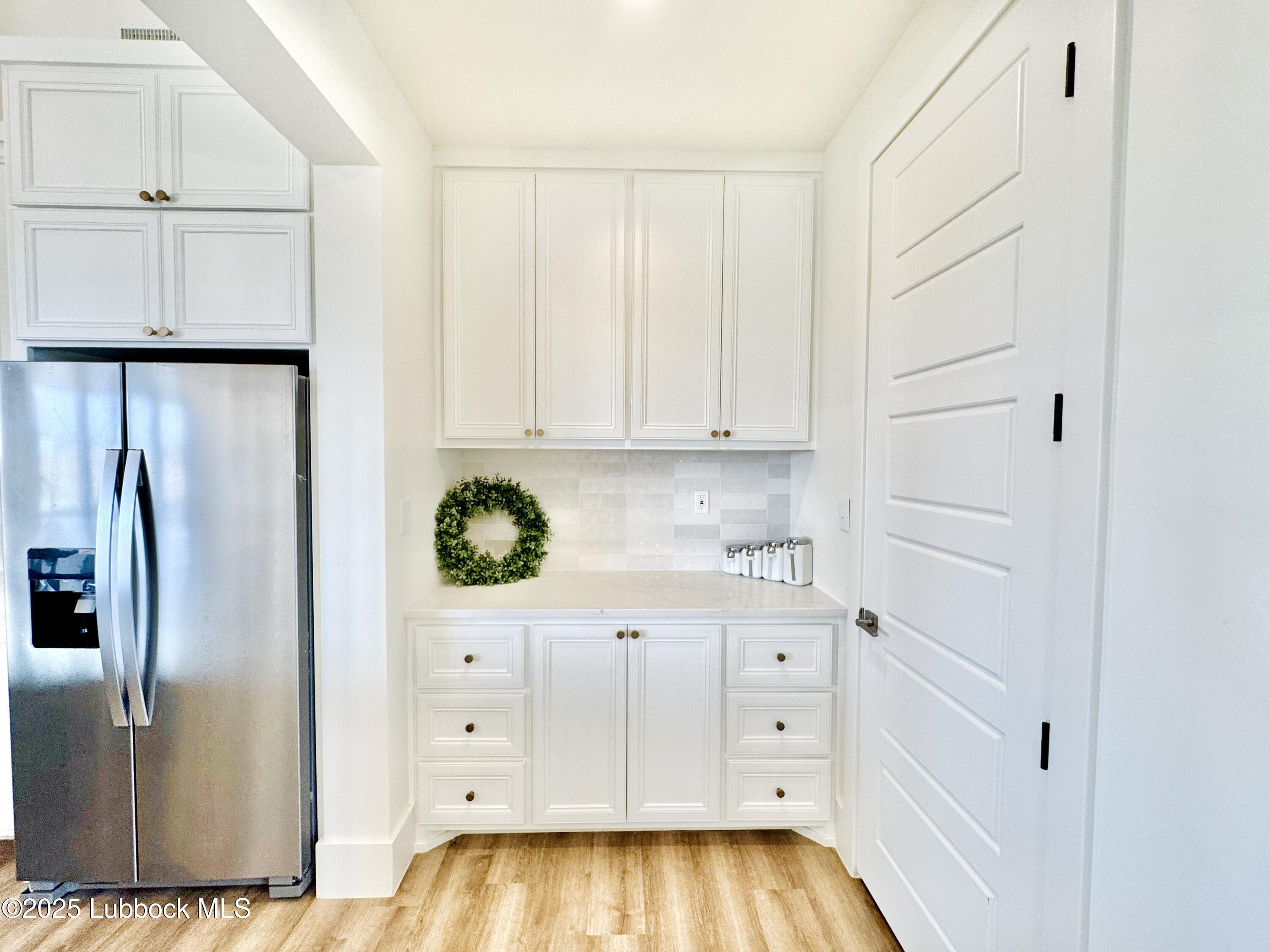 7211 West 12th Street Plainview, TX 79072 - Photo 20 of 48 a kitchen with white cabinets and refrigerator