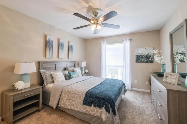 a bedroom with a large bed and a chandelier