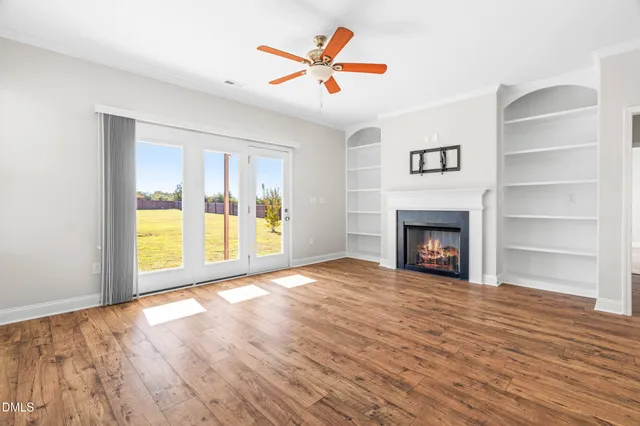 a view of an empty room with a window and a fireplace