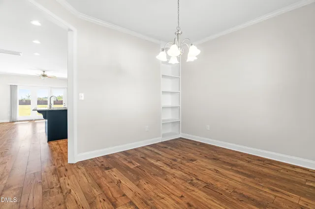 a view of a room with wooden floor and kitchen view