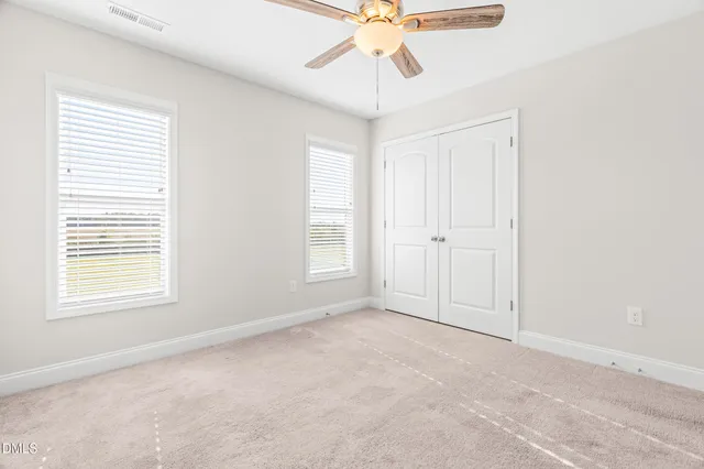 an empty room with a window and a fan
