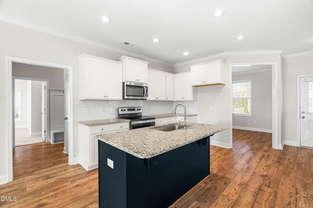 a kitchen with kitchen island granite countertop a sink counter top space and cabinets