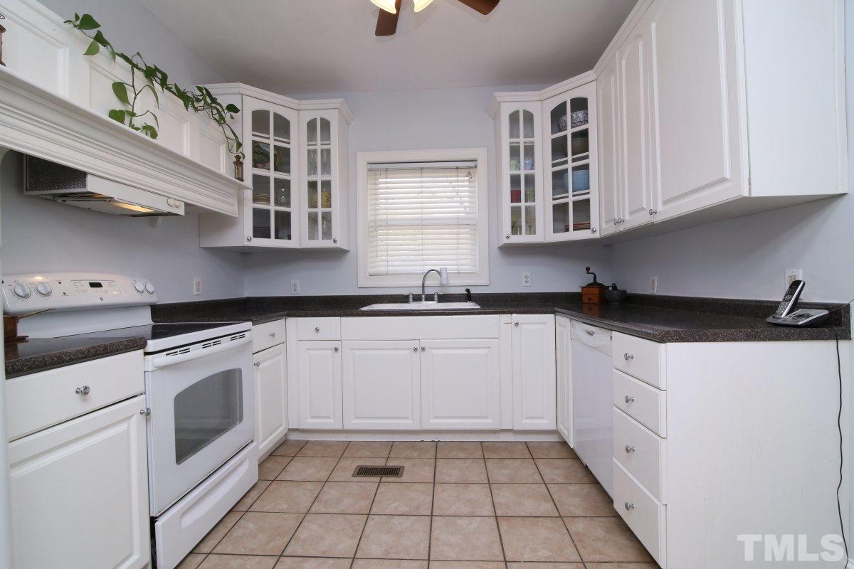 1011 Peace Street Raleigh, NC 27605 - Photo 5 of 25 a kitchen with stainless steel appliances granite countertop white cabinets and window