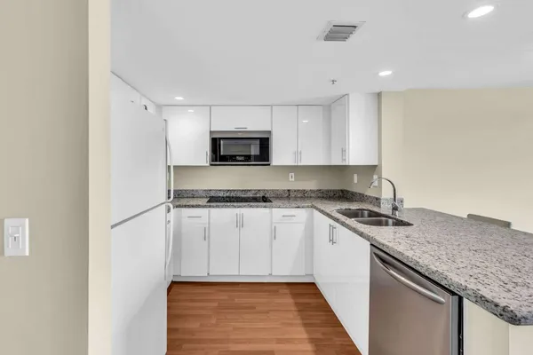 a kitchen with kitchen island granite countertop a sink stove and microwave