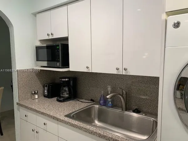 a kitchen with a sink and a washer dryer