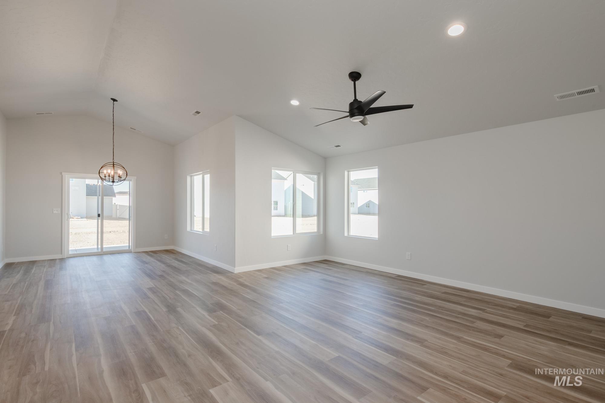 13723 Nisene Street Caldwell, ID 83607 - Photo 3 of 22 Empty room with lofted ceiling, light wood-type flooring, a ceiling fan, a chandelier, and recessed lighting