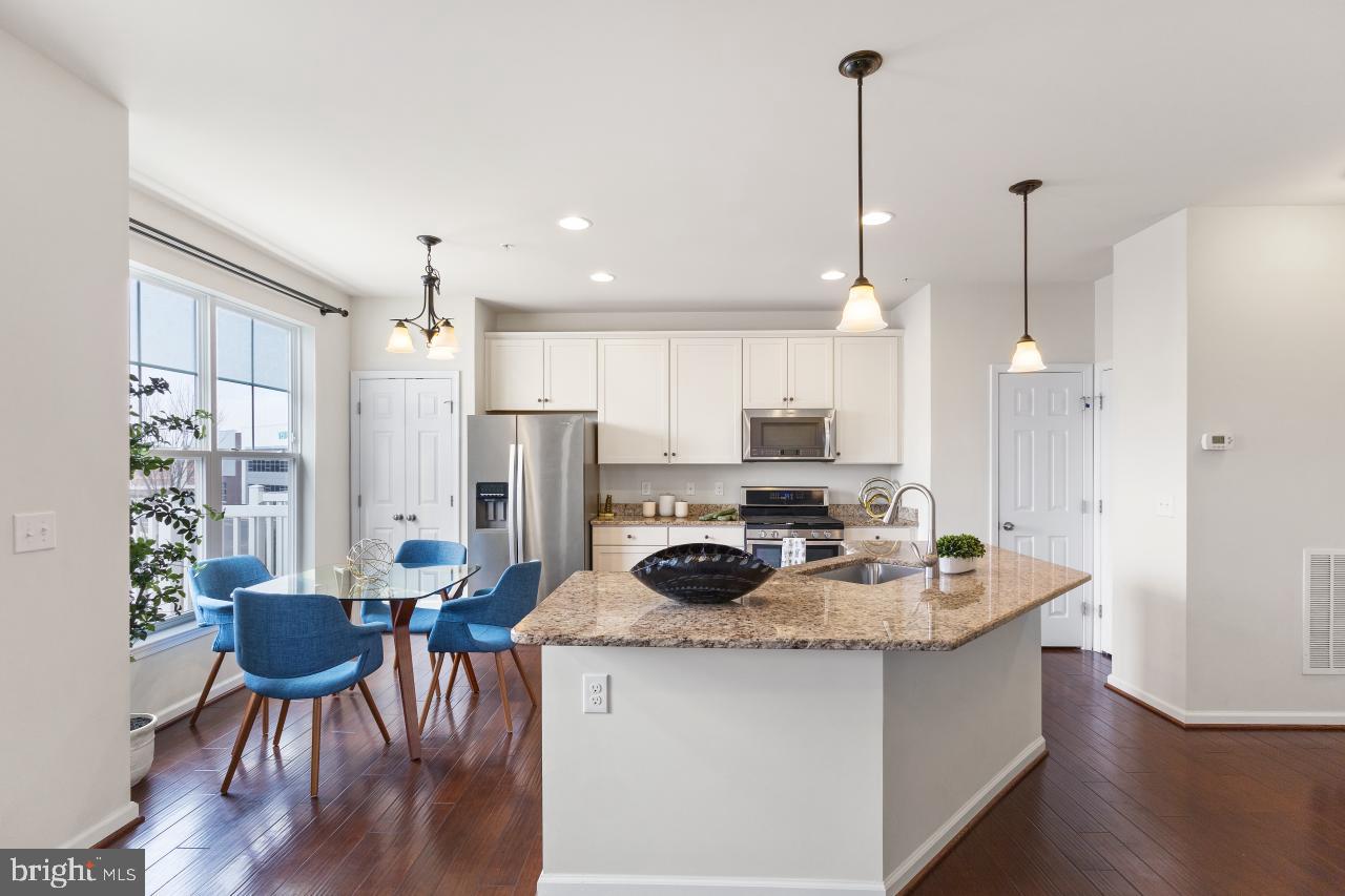 43367 Town Gate Square Chantilly, VA 20152 - Photo 6 of 36 a kitchen with a dining table chairs cabinets and stainless steel appliances