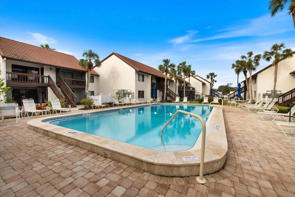 1610 Stickney Point Road, Unit 16101 Sarasota, FL 34231 - Photo 14 of 21 a view of a swimming pool with outdoor seating
