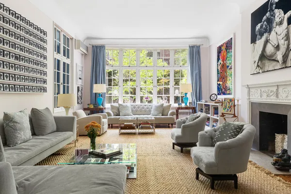 a living room with furniture fireplace and a large window
