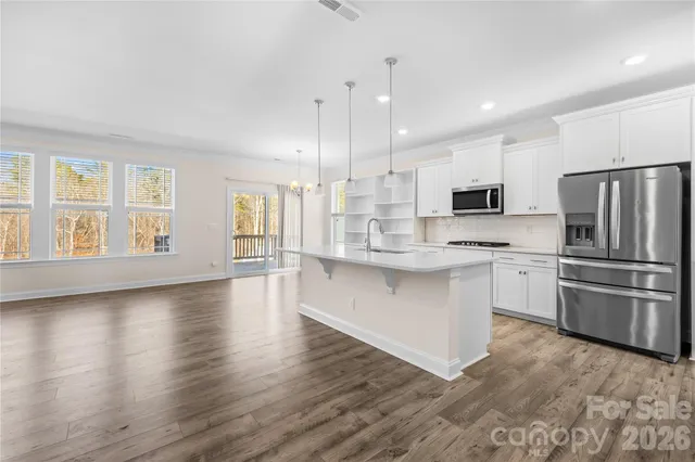 a kitchen with stainless steel appliances a refrigerator sink and microwave