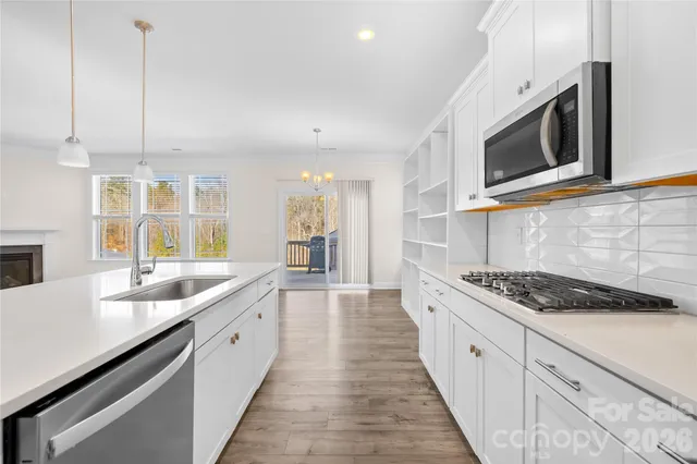 a kitchen with stainless steel appliances kitchen island granite countertop a sink and a microwave