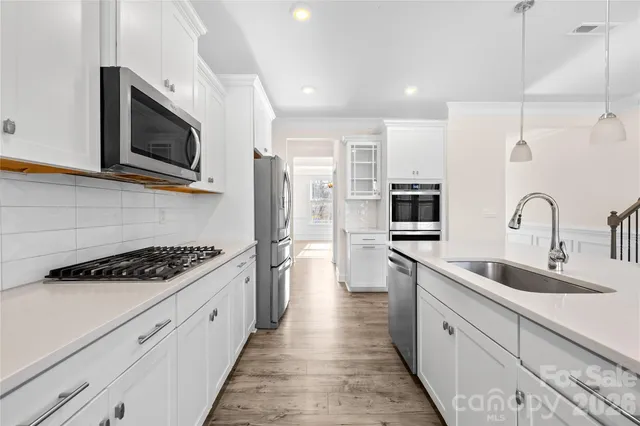 a kitchen with stainless steel appliances kitchen island a stove a sink and a microwave