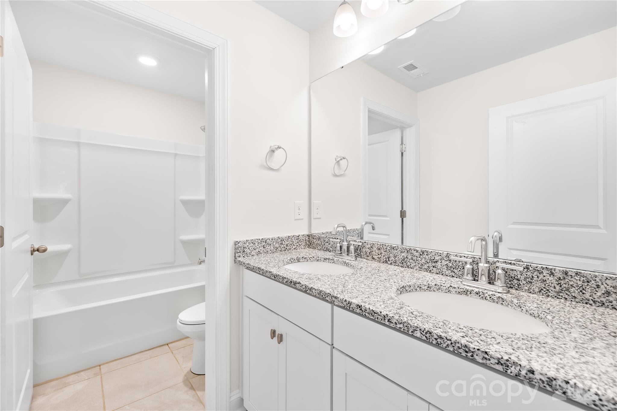 402 Preston Road Mooresville, NC 28117 - Photo 31 of 42 a bathroom with a granite countertop sink and a mirror with bathtub