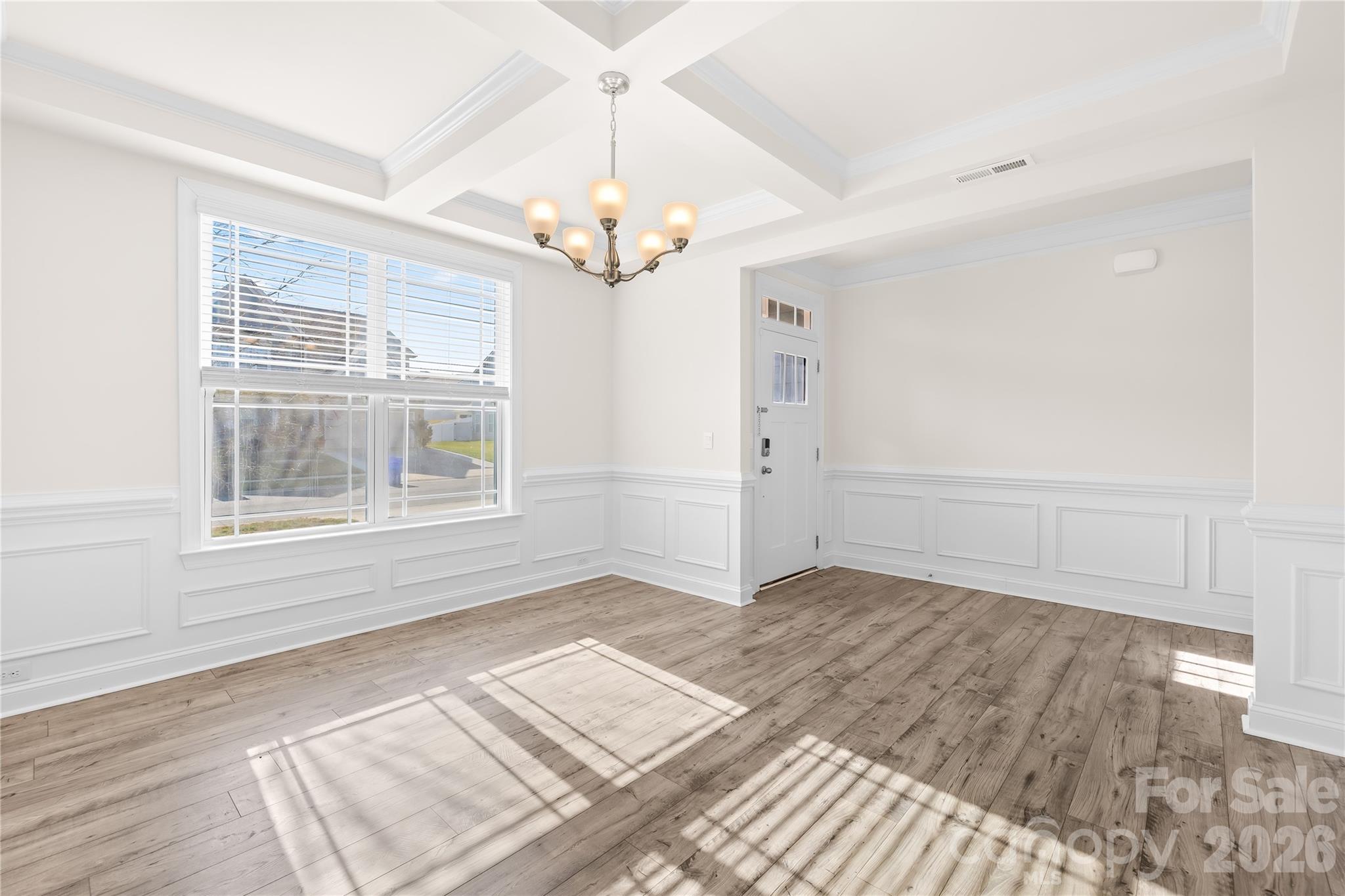 402 Preston Road Mooresville, NC 28117 - Photo 5 of 42 an empty room with wooden floor chandelier and windows