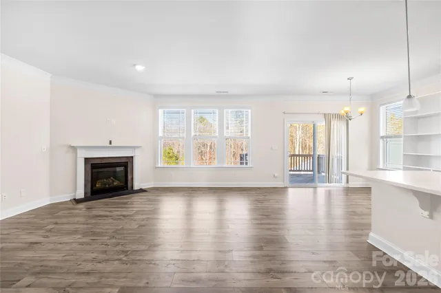 wooden floor fireplace and windows in an empty room