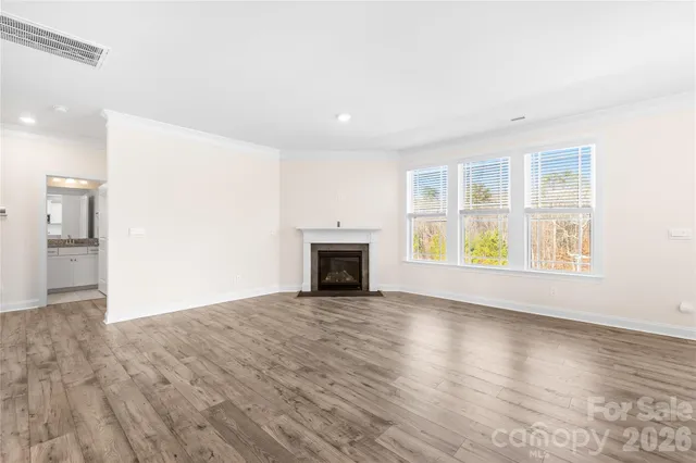an empty room with windows and fireplace