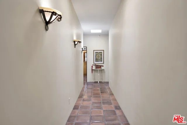 a view of a hallway with wooden floor and a bathroom