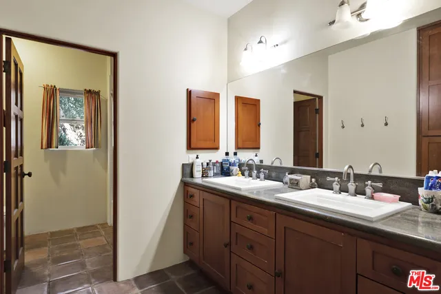 a bathroom with double vanity sinks and a mirror
