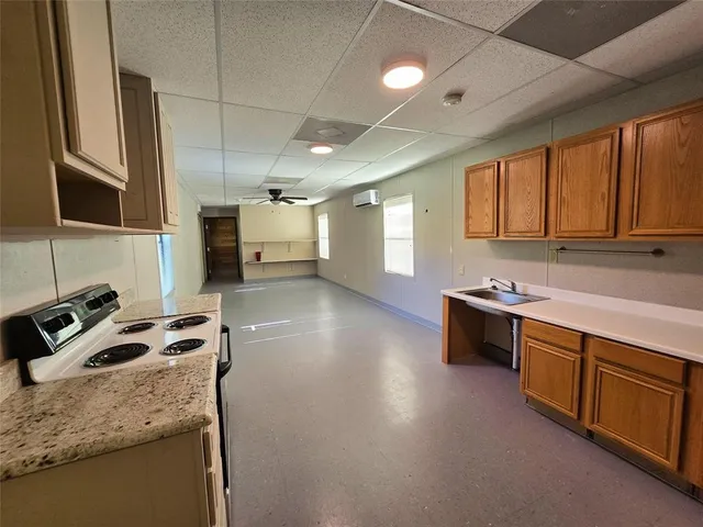 a kitchen with granite countertop a sink stove and cabinets