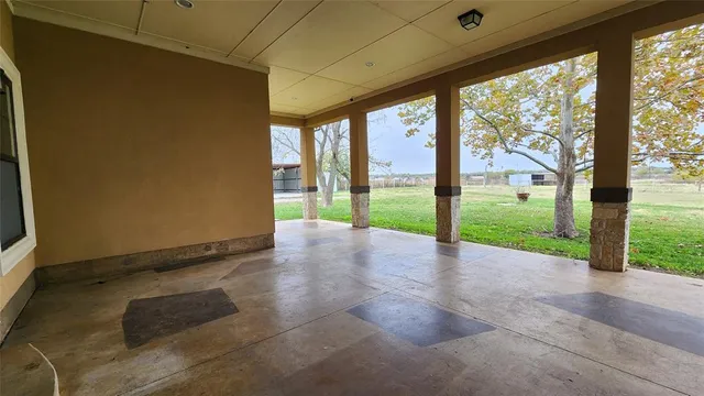 a view of an empty room with yard and a floor to ceiling window