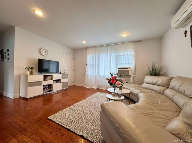 133 Railroad Avenue, Unit 2 Syosset, NY 11791 - Photo 1 of 11 a living room with furniture and a flat screen tv