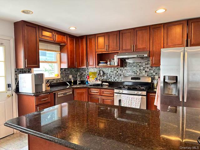 133 Railroad Avenue, Unit 2 Syosset, NY 11791 - Photo 3 of 11 a kitchen with stainless steel appliances granite countertop a refrigerator stove microwave and sink
