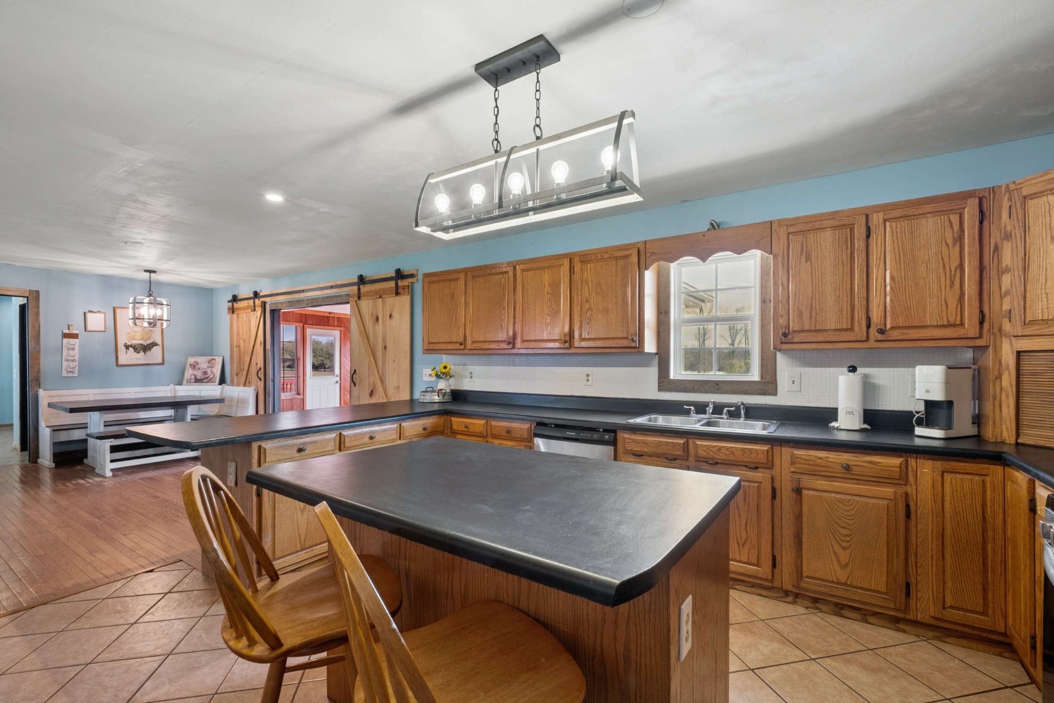 324 Laster-Holman Lane Decherd, TN 37324 - Photo 14 of 60 a kitchen with a stove a sink dishwasher a dining table and chairs with wooden floor