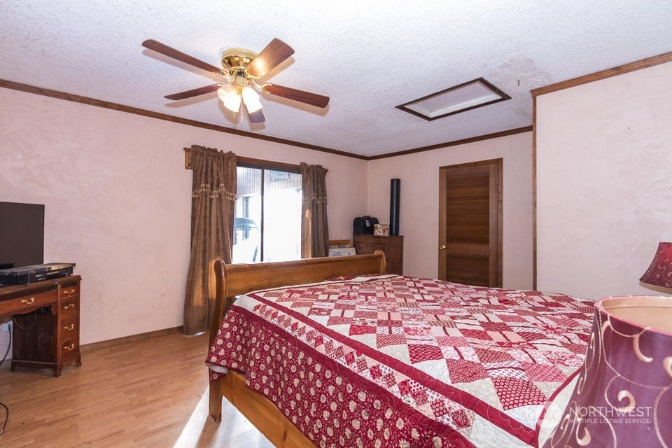 1144 State Rte 20 Colville, WA 99114 - Photo 14 of 38 a bedroom with a bed and a chandelier