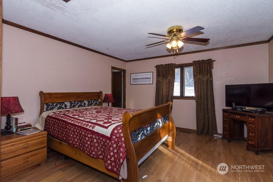 1144 State Rte 20 Colville, WA 99114 - Photo 15 of 38 a bedroom with a bed and a chandelier