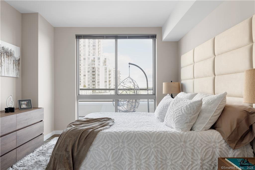 850 Pacific Street, Unit 448 Stamford, CT 06902 - Photo 11 of 16 a bedroom with a bed and a large window with outer view