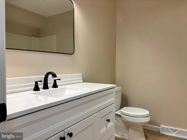 a bathroom with a toilet a sink and vanity