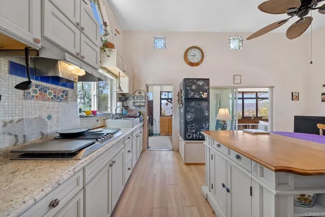 a kitchen with stainless steel appliances granite countertop a refrigerator and a stove top oven