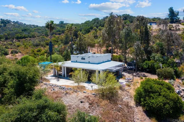 an aerial view of a house with a yard basket ball court and outdoor seating