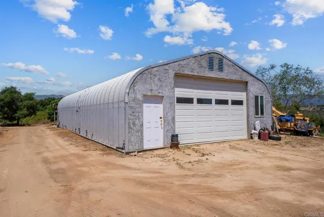 an aerial view of a house with a yard and mountain in the back