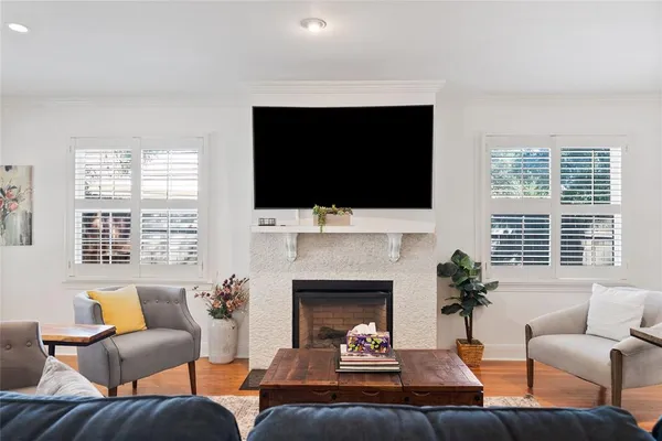 a living room with furniture a flat screen tv and a fireplace