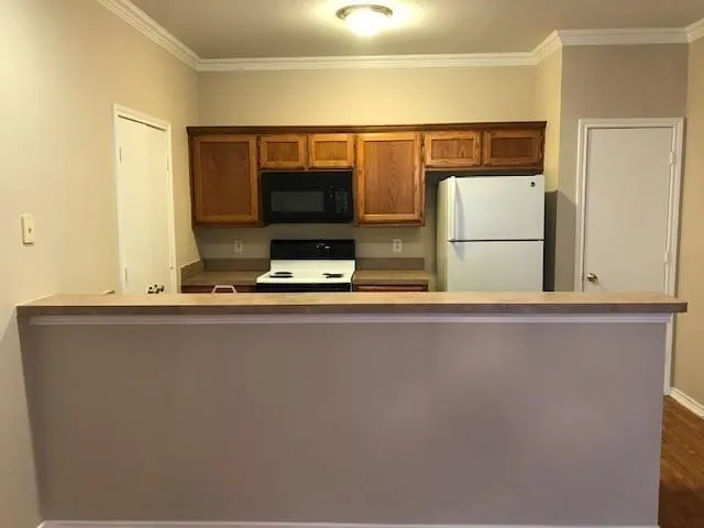 a living room with a flat screen tv and a refrigerator