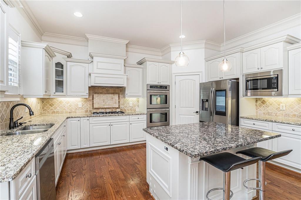 3301 Chastain Ridge Drive Marietta, GA 30066 - Photo 12 of 50 a kitchen with stainless steel appliances granite countertop a sink stove and refrigerator