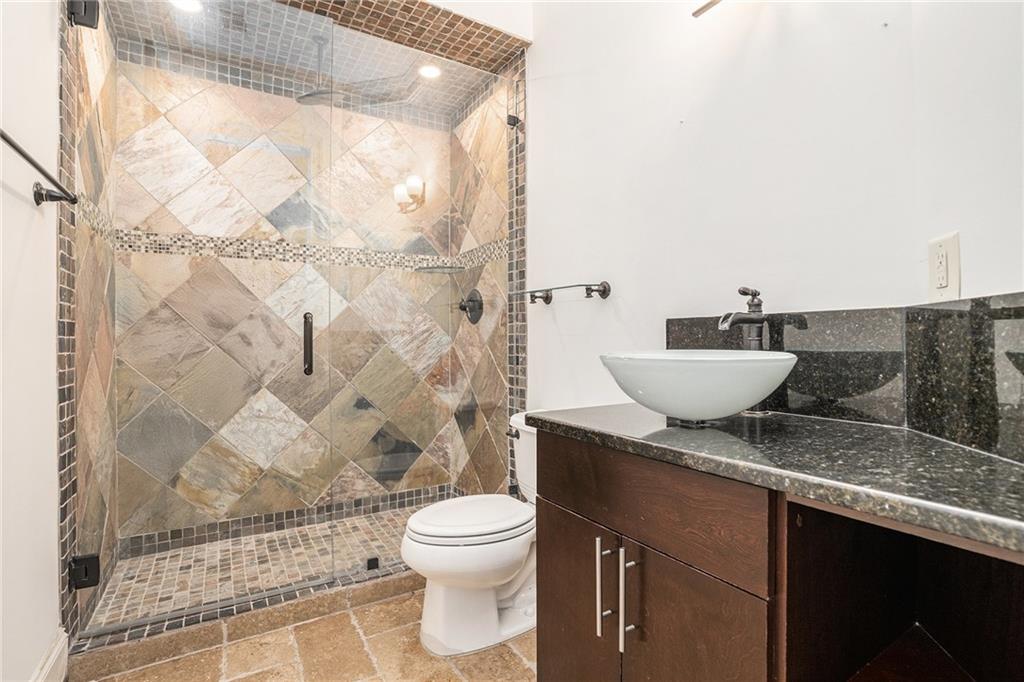 3301 Chastain Ridge Drive Marietta, GA 30066 - Photo 36 of 50 a bathroom with a granite countertop sink a toilet and a shower