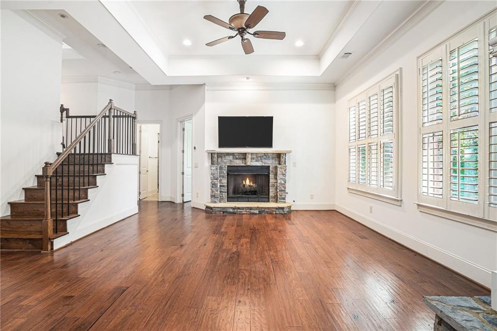 3301 Chastain Ridge Drive Marietta, GA 30066 - Photo 38 of 50 a view of a livingroom with wooden floor a fireplace a ceiling fan and windows
