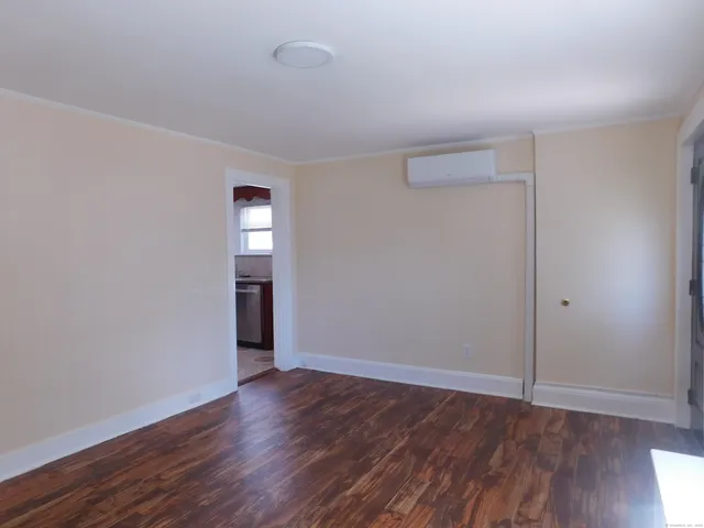 a view of an empty room with wooden floor and closet