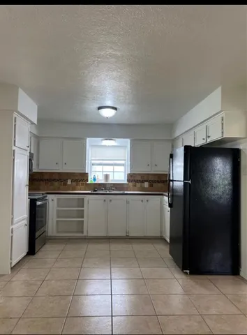 a kitchen with a refrigerator and cabinets