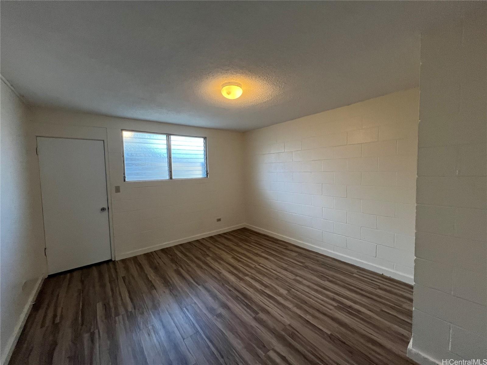 3121 Herbert Street, Unit 101 Honolulu, HI 96815 - Photo 3 of 6 an empty room with wooden floor and windows
