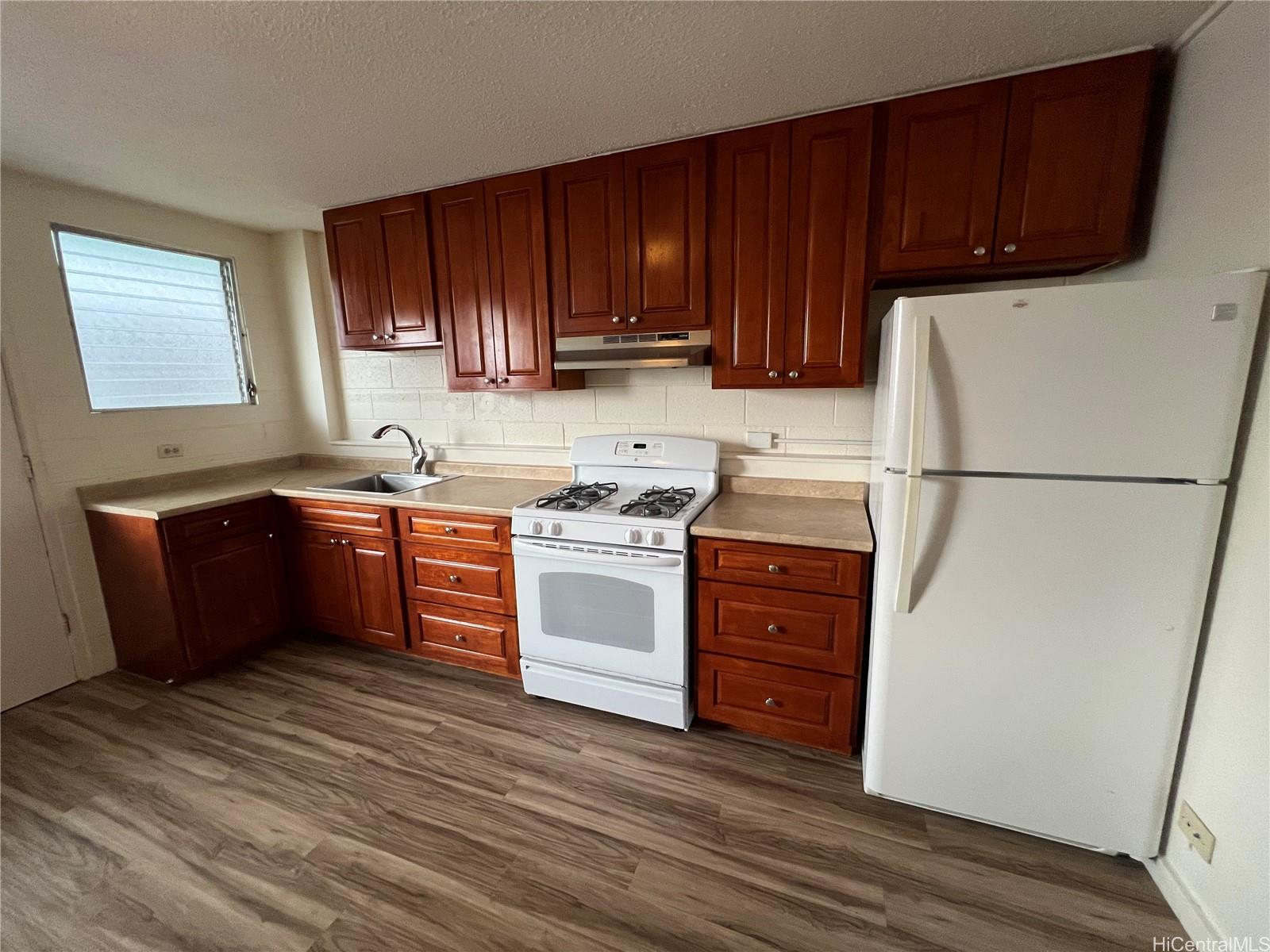 3121 Herbert Street, Unit 101 Honolulu, HI 96815 - Photo 5 of 6 a kitchen with stainless steel appliances granite countertop a refrigerator a sink dishwasher a stove top oven a refrigerator and cabinets with wooden floor