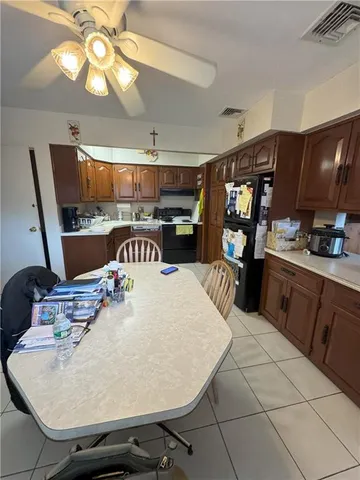a kitchen with stainless steel appliances granite countertop a sink a stove and a dining table