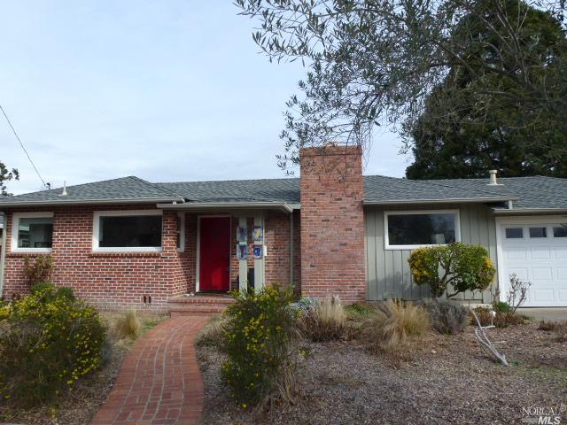 a front view of a house with yard and trees