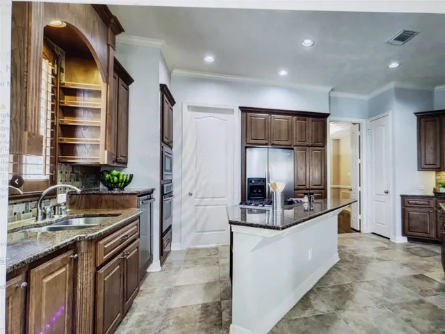 a kitchen with stainless steel appliances granite countertop a sink stove and refrigerator